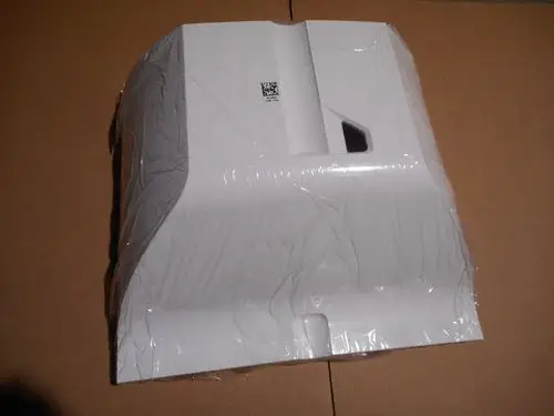 Remeha Brennerhaube in schlichten Weiß, verpackt und frisch, mit sichtbarem QR-Code auf der Oberseite, auf neutralem Kartonhintergrund platziert.